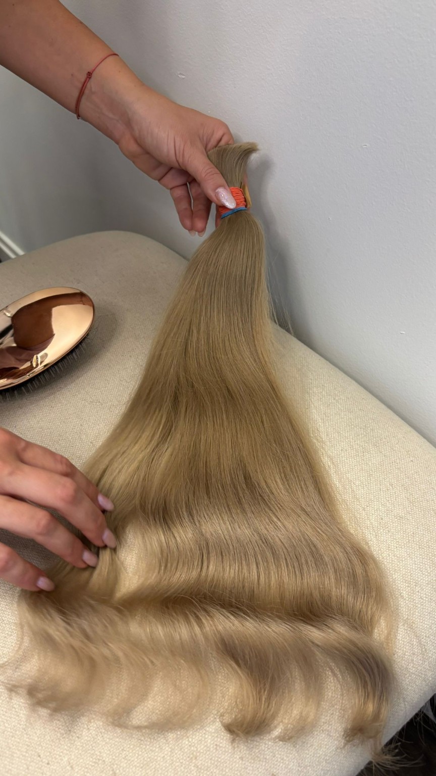 Long soft blonde extension hair selected for custom preparation